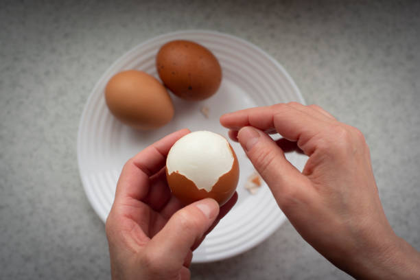 sbucciatura femminile caucasica uova sode vista dal basso - hard cooked egg foto e immagini stock