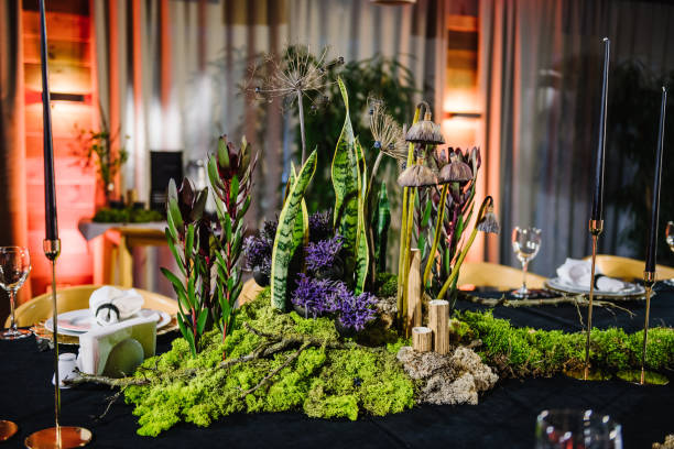 istock Wedding reception. Rustic. Composition of bark tree, wooden decor, moss in restaurant. Table decorated plates and glasses, candles, flowers, greenery. Interior of table for guests with natural decor. 1490658887