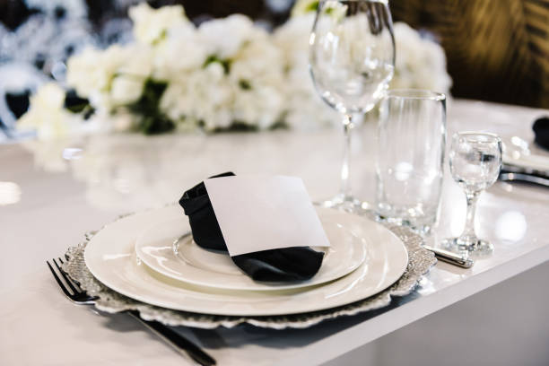 istock Serving, setting table. Plate decorated linen black napkin, postcard, silverware cutlery, glasses. Side view. Closeup. Wedding set up, dinner table reception. Birthday, baptism, event. 1490658904