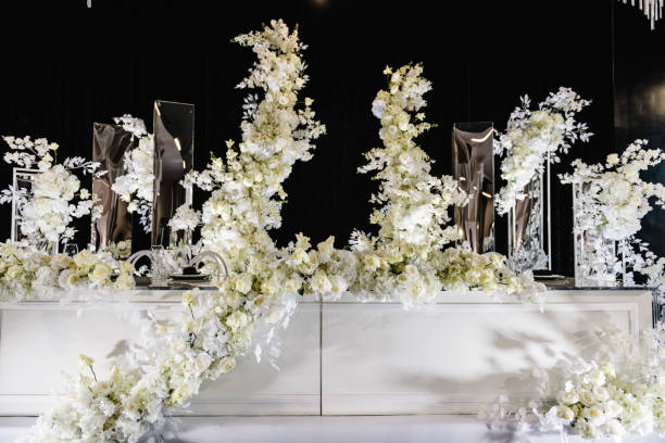 istock Festive table with arch decorated composition flowers and greenery, candles in hall restaurant. Table newlyweds in banquet area on a wedding party. Luxury silver decor. Table setting, reception. 1490658912