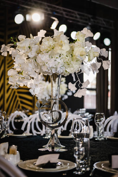 istock Table number 5. Setting, and serving guests closeup. Stands, sign number five. Closeup. Wedding setup detail. Festive table covered black tablecloth, decorated composition flowers in party area. 1490658920