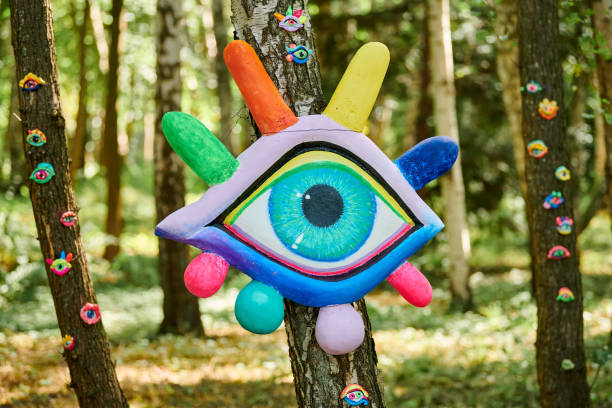 istock Art object of human eyes on tree trunk in green forest background, trees sight feeling ecological concept 1490659937