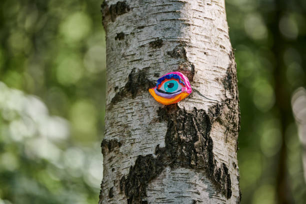 istock Art object of human eyes on tree trunk in green forest background, trees sight feeling ecological concept 1490660371