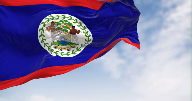 национальный флаг белиза развевается на ветру в ясный день - flag of belize стоковые фото и изображения