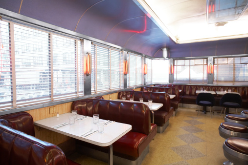 Inside a diner with dark purple booths and neon lighting.