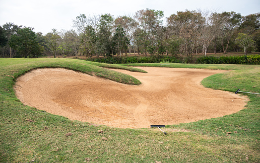 A bunker is positioned in the golf hole to guard the desired position in the landing area or green.