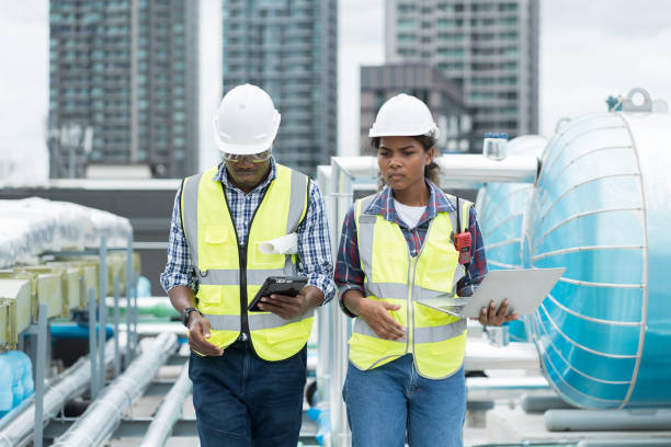istock Male and female engineer worker working with laptop computer discuss and inspecting structure of building at rooftop of building at construction site 1490662979