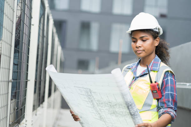 istock Female engineer worker working, holding blueprint and inspecting structure of building at rooftop of building at construction site 1490663021