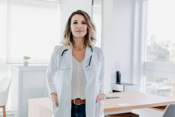 Portrait of female doctor looking at camera in doctor's office Portrait of female doctor looking at camera in doctor's office seria stock pictures, royalty-free photos & images