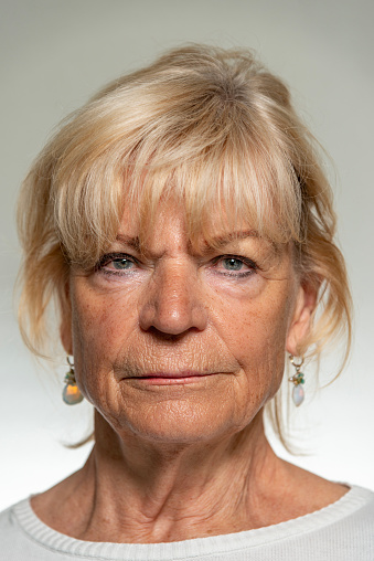 Studio shot of a senior woman standing against a gray background
