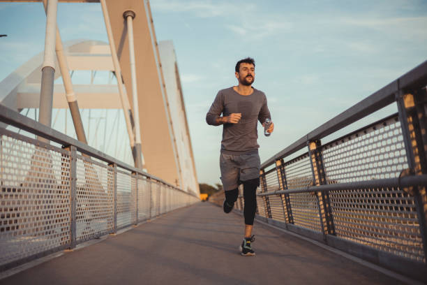 istock Athletic Man Jogging in the City During Sunset 1490666305