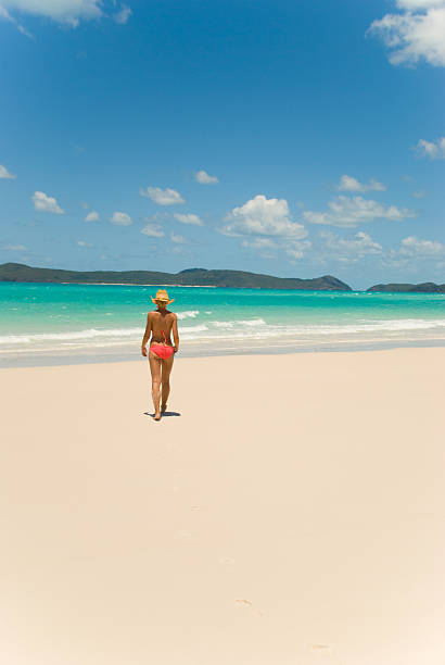 Girl walking on the beach This photo was taken at Whitehaven Beach, Whitsunday Islands, Australia. swimwear bikini top bikini bikini bottom stock pictures, royalty-free photos & images