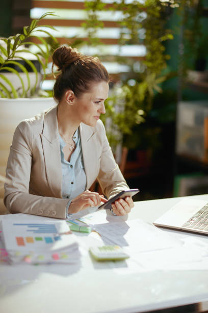 istock modern bookkeeper woman in modern green office using smartphone 1490670026