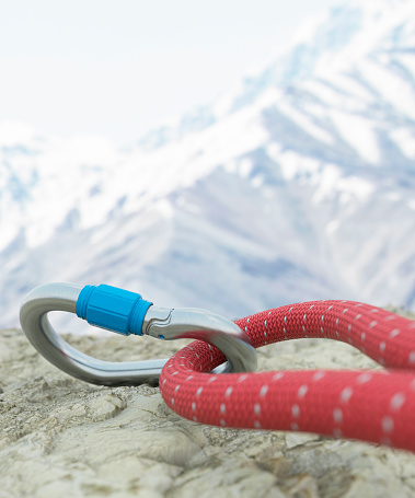 Mountaineering carabiner attached to a rope on a rock climbing trail 3d render
