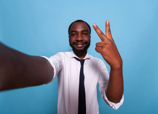 istock Smiling vlogger showing peace sign at camera in videocall conference 1490672506