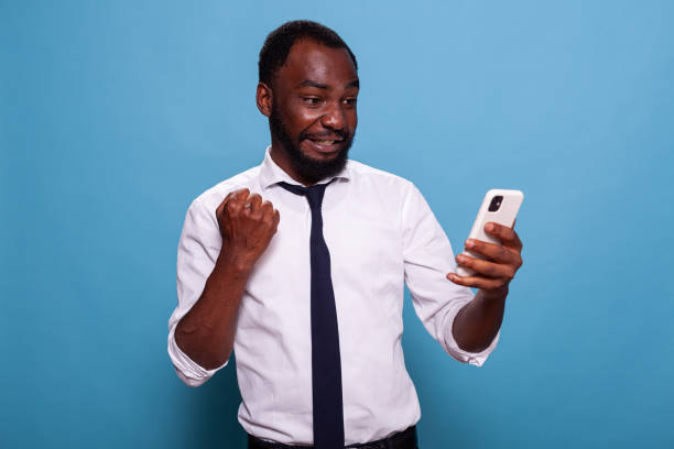 istock Man in white shirt holding smartphone winning online mobile game 1490672889