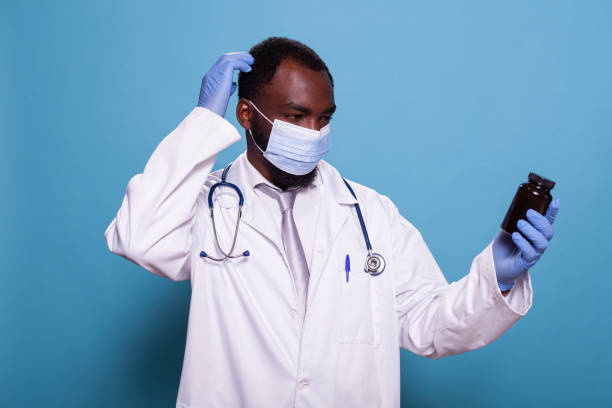 istock Baffled doctor looking baffled at prescription pill bottle 1490673591