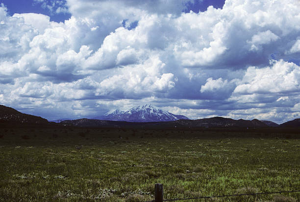 meadow and mountain, circa 1987 Meadow/pasture and extreme clouds, with snowcapped mountain in the distance. Near Fort Union National Monument. hearkencreative stock pictures, royalty-free photos & images