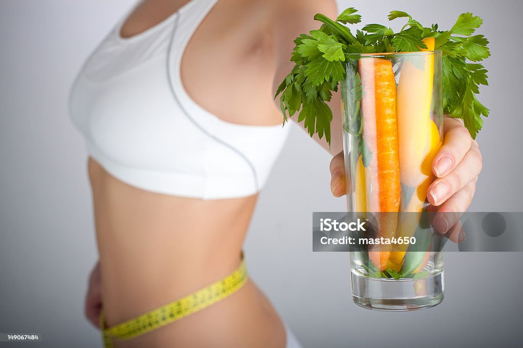 Diet Woman Concept image of a woman holding a glass of vegetables in front of her body Adult Stock Photo