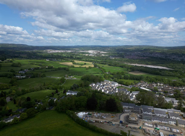 DRONE AERIAL VIEW: A building construction site featuring new build houses on Green Belt land (bottom right corner of picture); countryside looking towards Dartmoor National Park in the distance. highweek, newton abbot, devon, inglaterra: drone aerial view: un sitio de construcción de edificios con casas de nueva construcción en terrenos del cinturón verde cerca del pueblo de highweek; campo mirando hacia el parque nacional de dartmoor en la dis