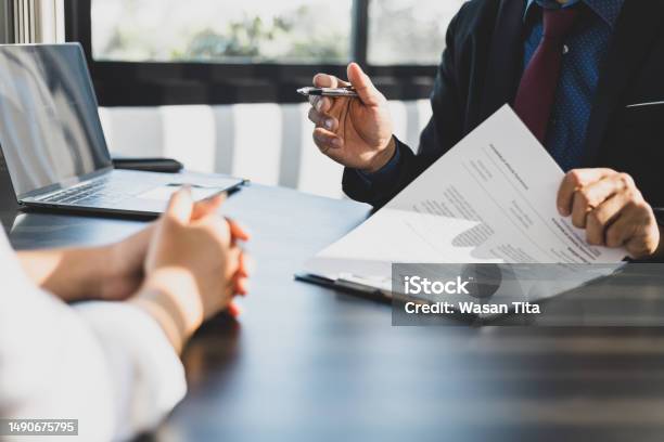 Businessman In Suit In His Office Showing An Insurance Policy And Pointing With A Pen Where The Policyholder Must To Sign Insurance Agent Presentation And Consulting Insurance Detail To Customer Stock Photo - Download Image Now