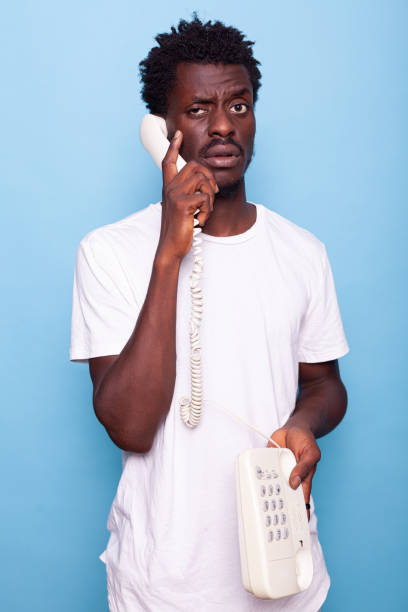 istock Young adult answering call on retro telephone in studio 1490680917