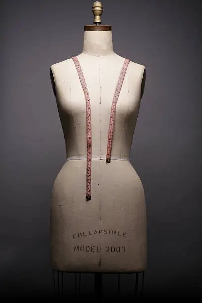 Photo of An undressed mannequin with a tape measure draped on it