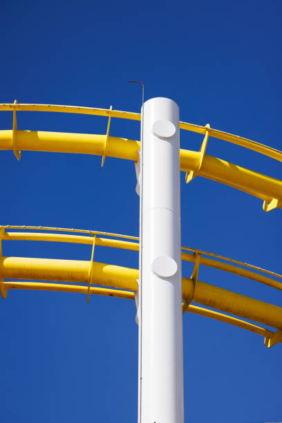 istock Vibrant yellow roller coaster track isolated against the backdrop of a blue sky. 1490683235