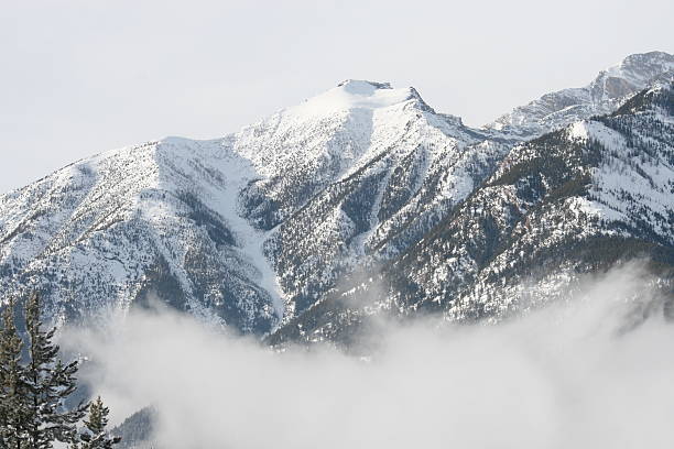 mountain peak above clouds stock photo