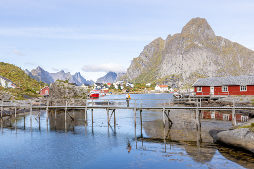 She looks around the beautiful scenery on a sunny day.\nLofoten islands, Norway