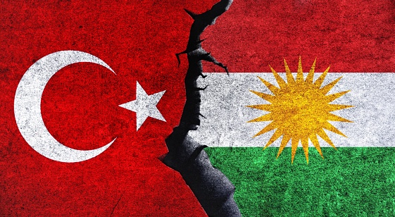 Flag of Turkey and Kurdistan on wall with crack. Diplomatic relations between Kurdistan and Turkey