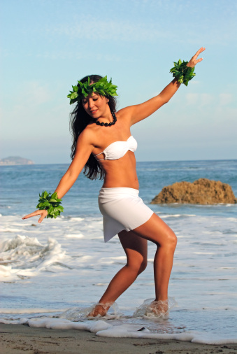 beautiful young Polynesian woman performing traditional dance on beach