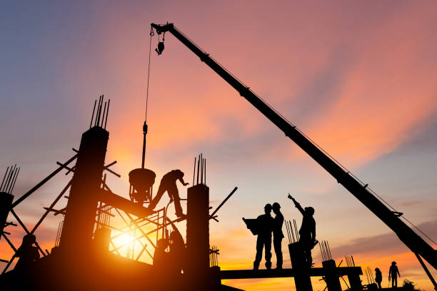 istock Silhouette of Engineer and worker team checking project at building site background, construction site with sunset in evening time background 1490687425