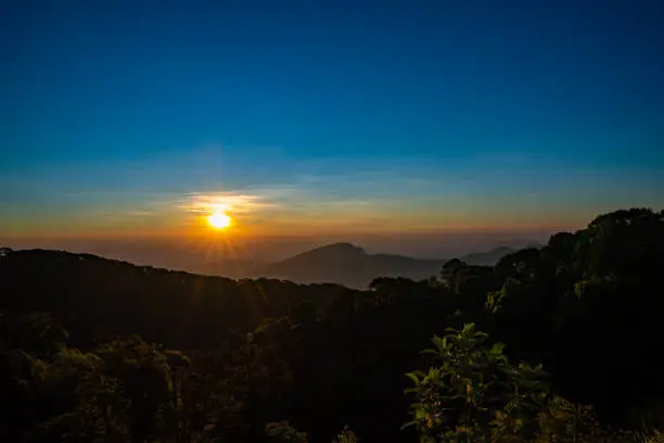 The beautiful sunrise at Doi intanon national park, Chiang Mai in the morning.Sun is rising from the hill to shy with beautiful yellow orange light.