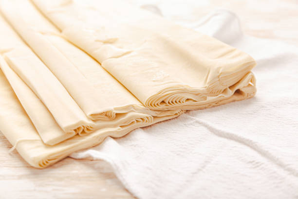 Raw phyllo pastry, thin filo dough for baking, for pie and cakes on wooden kitchen table