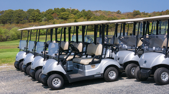 North Truro, Massachusetts, USA- May 11, 2023-  Several Yamaha electric golf carts await the busy golfing season in the shadow of the Cape Cod lighthouse.