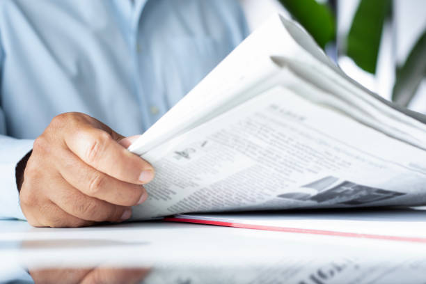 istock businessman reading newspaper at office 1490692511