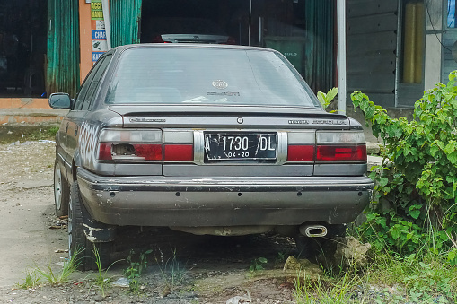 Bogor, Indonesia - February 4, 2023: Rear view of an old Japanese made car, Toyota Corolla - GT Twin Cam 16, parked on the side of the road.