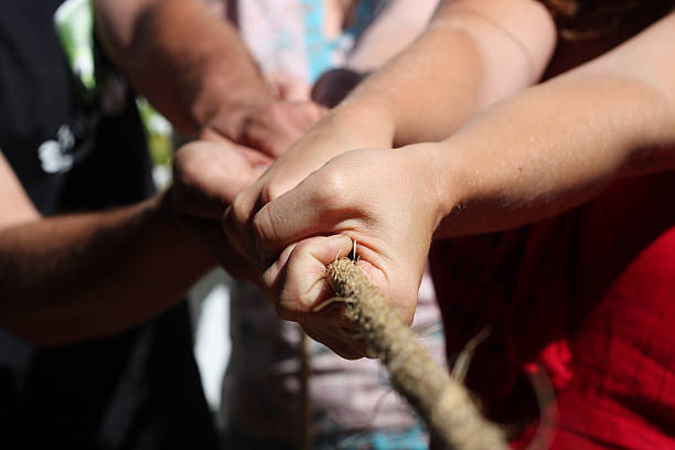istock Close up of hands pulling a rope in tug of war 149069431