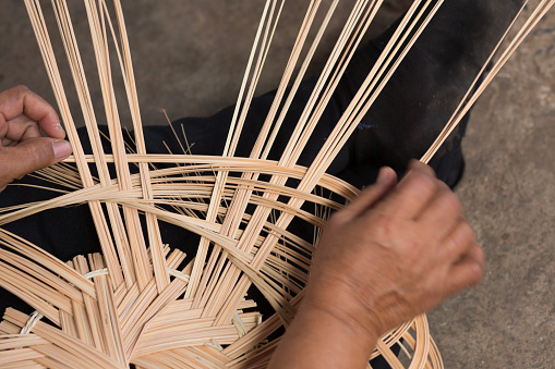 Woman weaves basket. Woman hand working crafts weaving palm leaf making basket.
