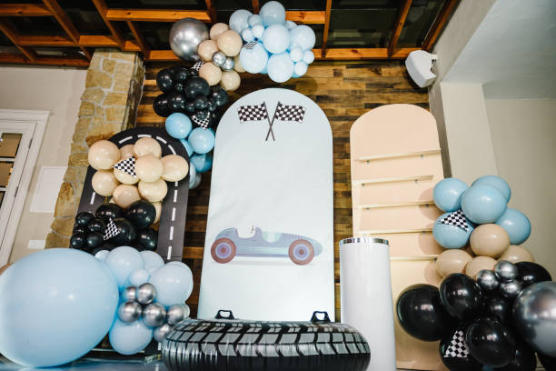 istock Birthday decorations with blue, brown, black, silver balloons for party. Arch for a celebration event. Photo wall decoration space or place for text. Trendy decor with flag, race, wheel, car for boy. 1490697769