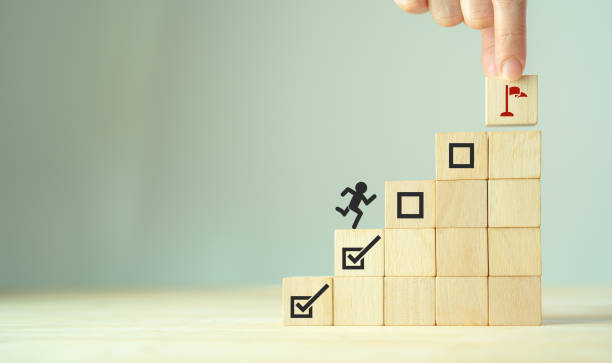istock Work in progress concept. Goals, targets, tasks tracking. Goals achievement and business success.  Task completion. Managing project timeline. Wooden blocks with target achievement icon. 1490699989