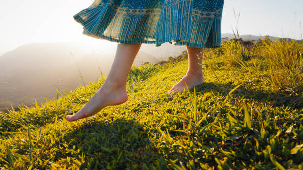 드레스를 입은 여자가 맨발로 잔디밭을 걷는다 - barefoot 뉴스 사진 이미지