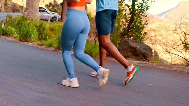 Fitness, training and shoes of couple running in a road for exercise, health and morning cardio in nature. Runner,  sports and people feet outdoor for workout, performance and endurance challenge