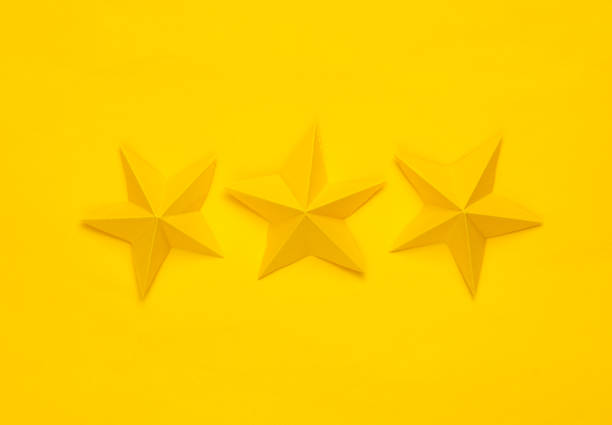 istock Three paper stars on yellow background. Service rating 1490706934