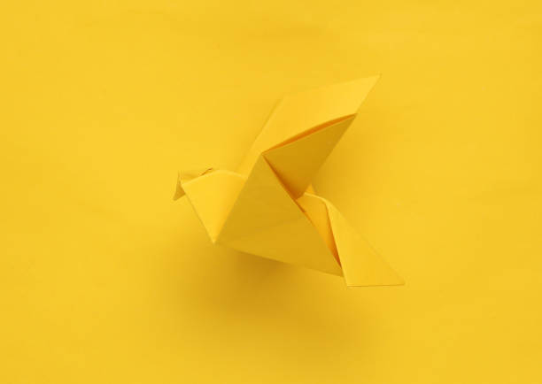 istock Yellow origami dove on yellow background 1490707608