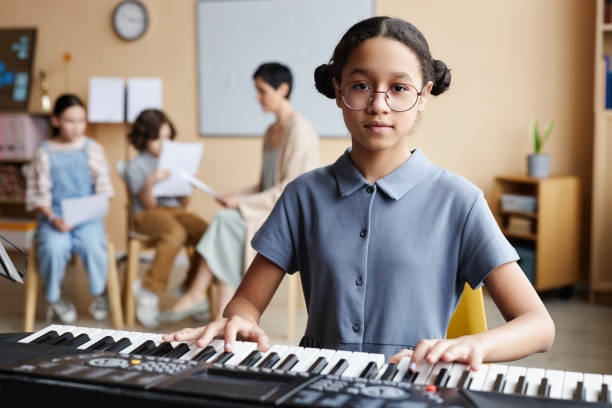 istock Schoolgirl playing piano in music class 1490709050