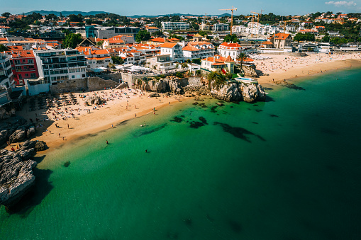 Drone aerial view of Praia da Rainha and Conceicao next to the historic city centre of Cascais, Portugal