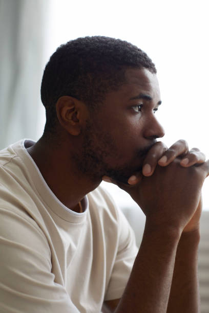 Pensive man sitting in his bedroom