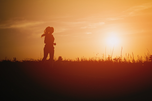 teenage girl runner countryside in sunset, sport photo with copy space